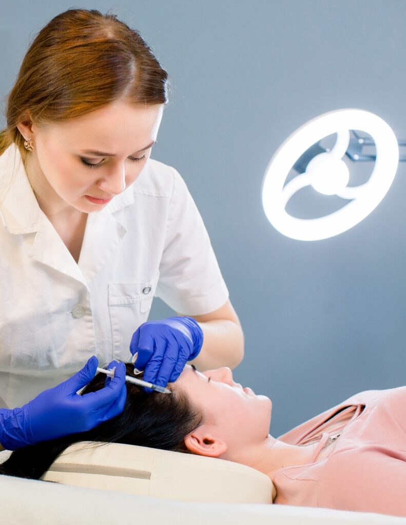 Procedure of hair mesotherapy. Young woman doctor cosmetologist makes the procedure of mesotherapy