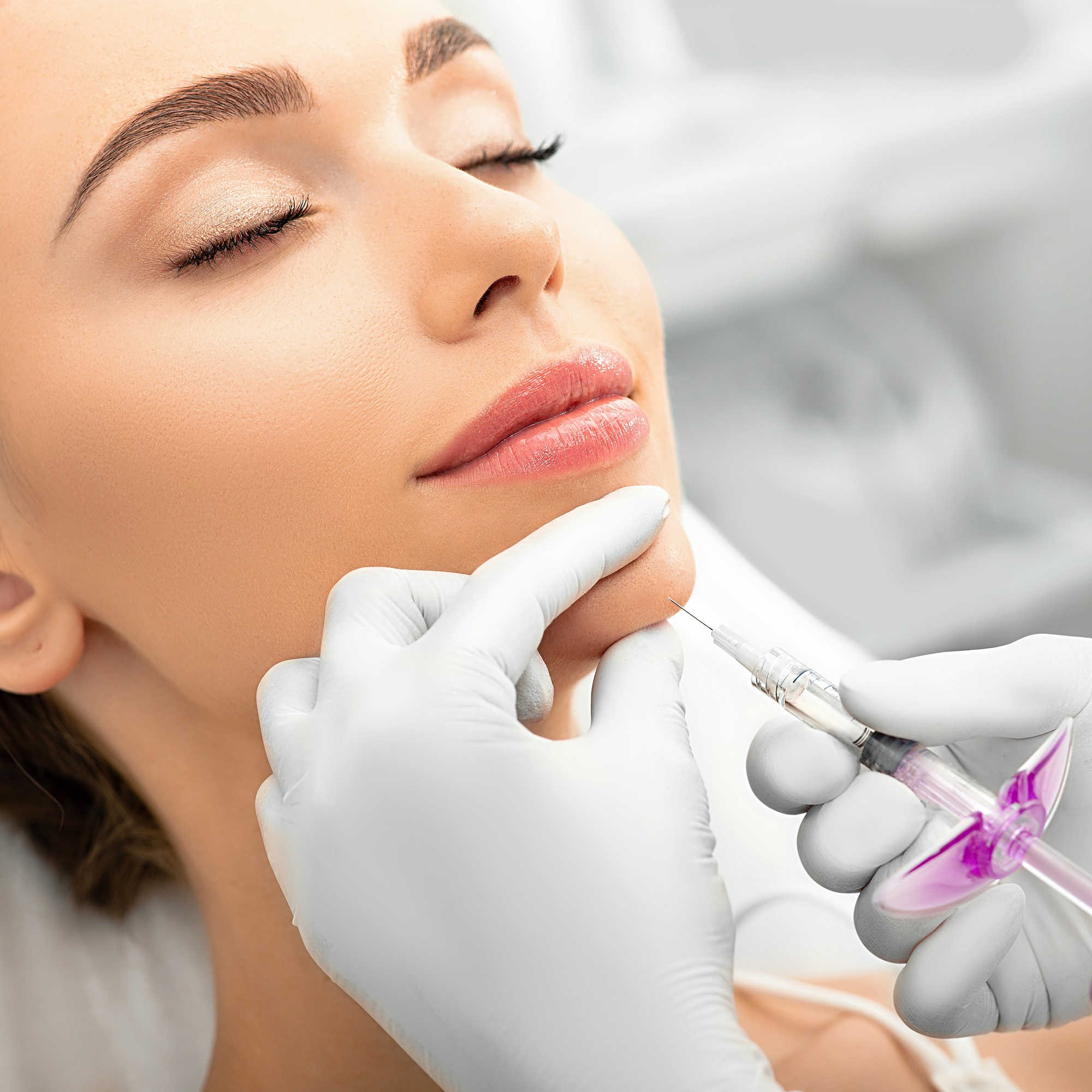 Woman during skin tightening procedure, injection of dermal filler into a female face. The anti-